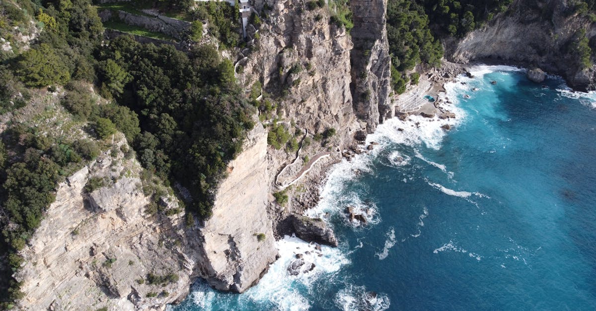 Stunning aerial view of the rugged Amalfi coastline with cliffs and turquoise sea in Italy.