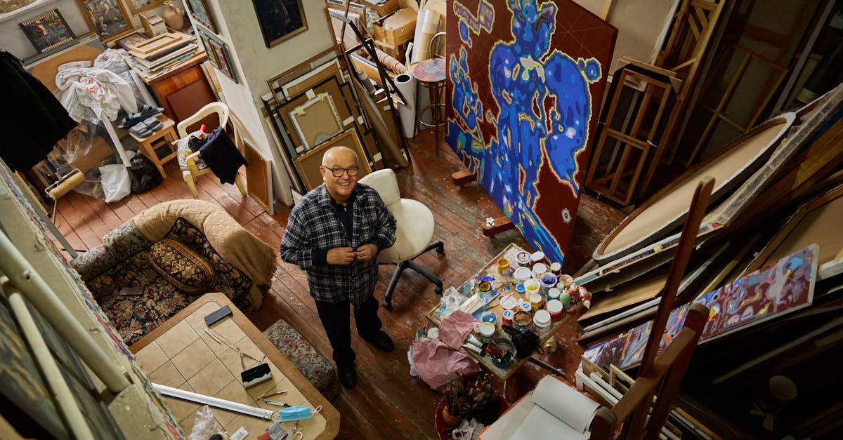 Creative artist in his vibrant studio with paintings and art supplies around.
