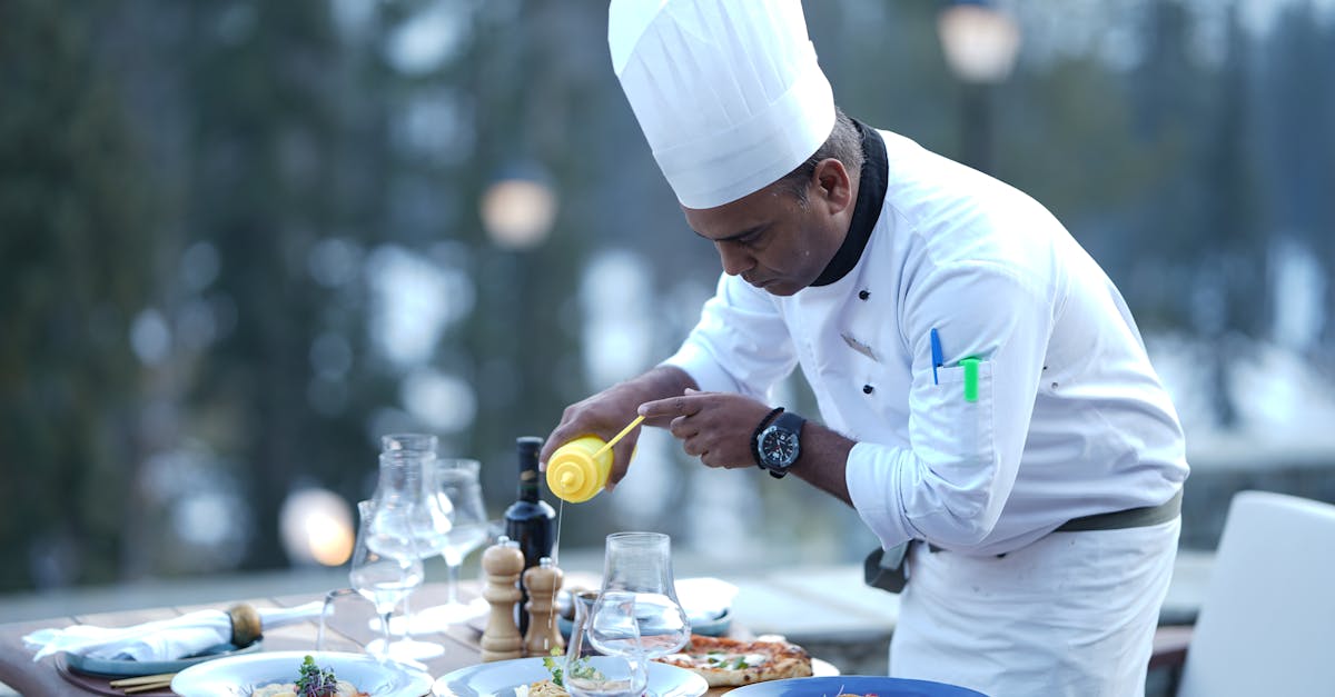 A chef skillfully prepares dishes for a stunning outdoor dining experience, showcasing food artistry.