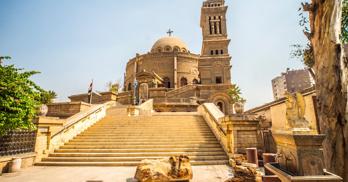 Exterior view of the historic St. George's Church in Cairo, showcasing its iconic tower and grand entrance stairs.