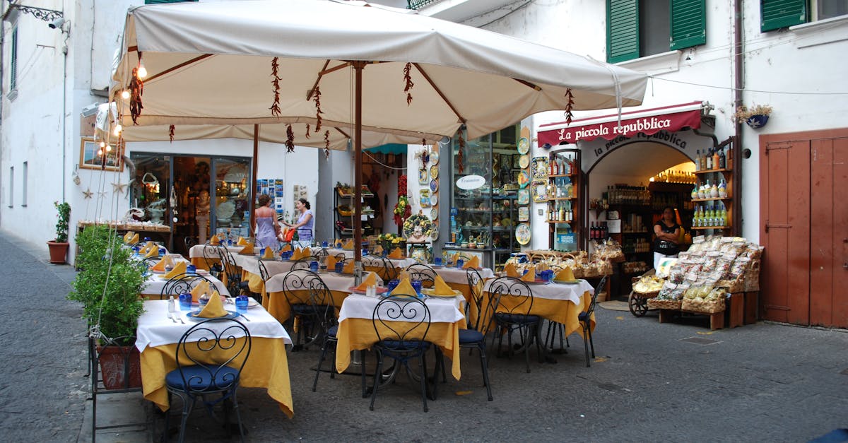 Picture of an outdoor café in the Amalfi Coast, Italy with tables, chairs, and umbrellas setting a vacation vibe.