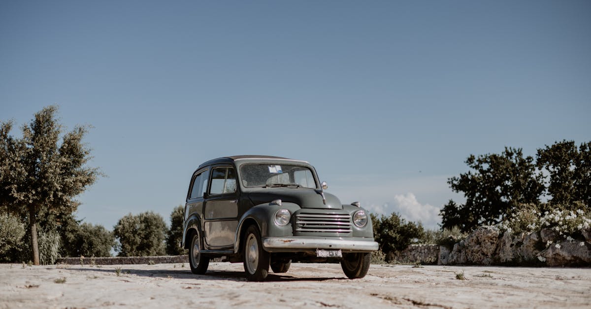 Classic Fiat 500 Topolino parked outdoors in Ostuni, Apulia, Italy under a clear, sunlit sky.
