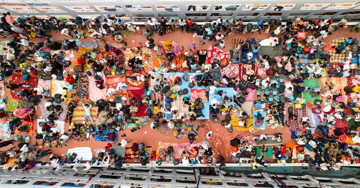 A detailed overhead view of a bustling market gathering with colorful textiles and people interacting.
