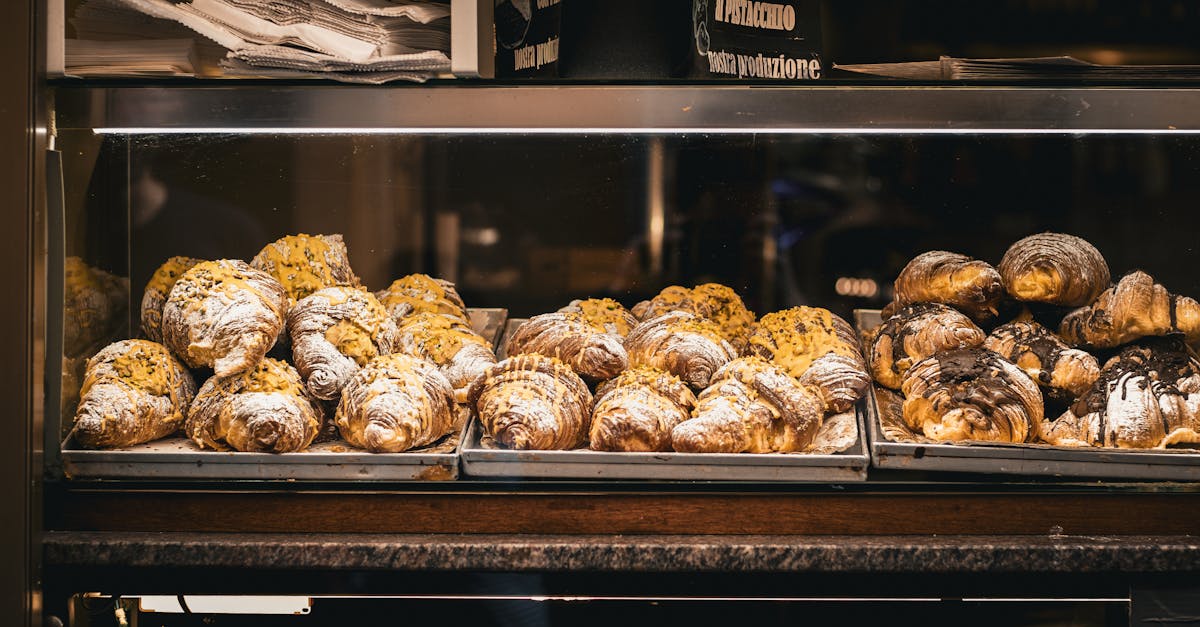 A tempting selection of fresh croissants displayed in a bakery window in Rome, Italy.