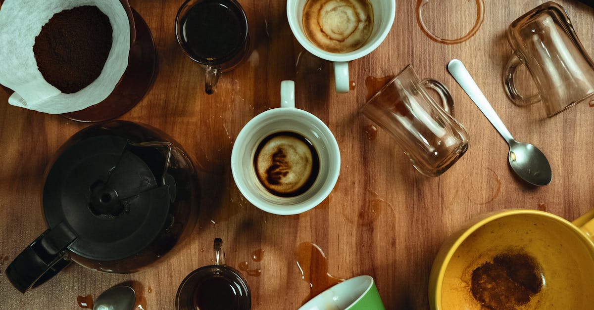 Artistic top view of empty coffee cups with spilled stains on a wooden table.