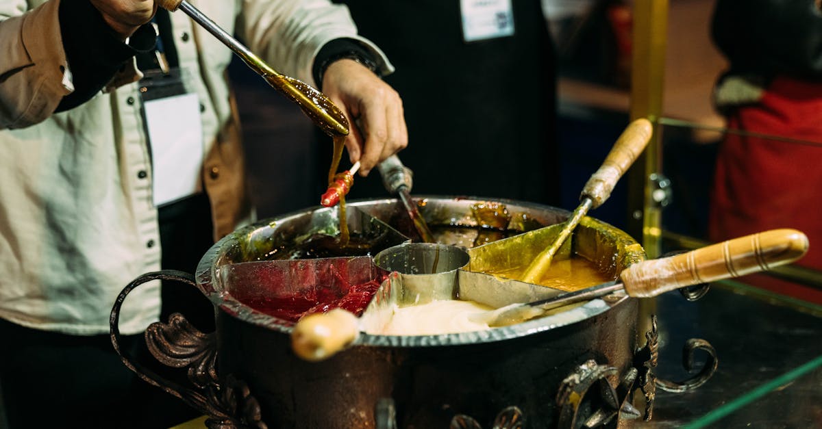 Close-up of hands crafting traditional sweets in an artisan kitchen setting.