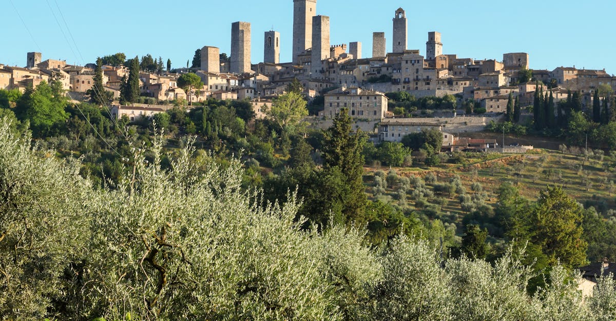 Dramatic skyline of historic San Gimignano with iconic towers amidst lush Tuscan landscape.