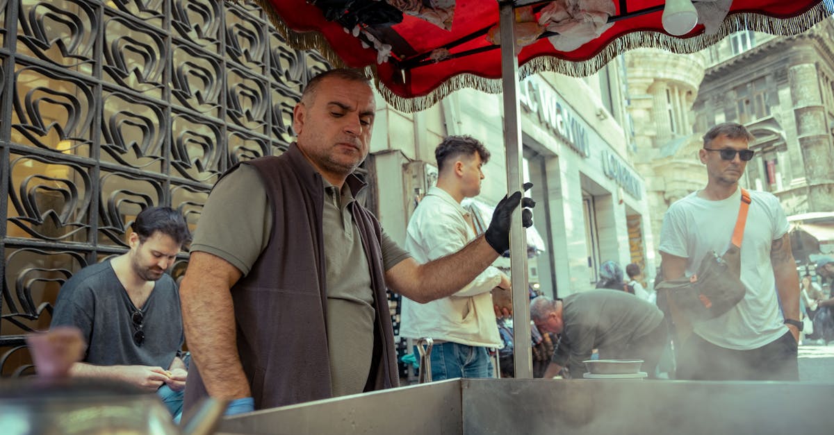Street vendor cooking food in a bustling city market, surrounded by customers.
