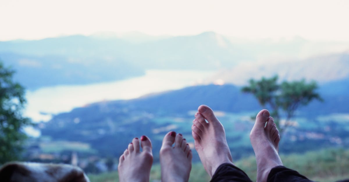 Two people relaxing with a scenic view of mountains and valley in Switzerland.