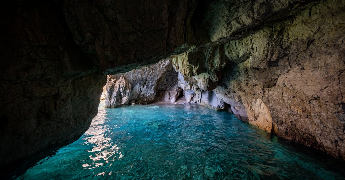 Explore stunning turquoise waters and rock formations inside a serene limestone cave.