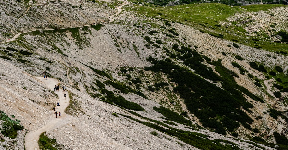 Aerial view of hikers on rugged mountain trails in summer, showcasing scenic landscapes and outdoor adventure.