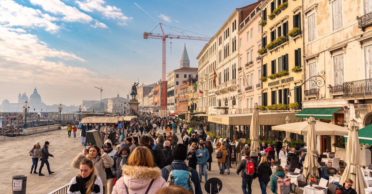 Crowded street in Venice, Italy showcasing vibrant urban life along colorful buildings.