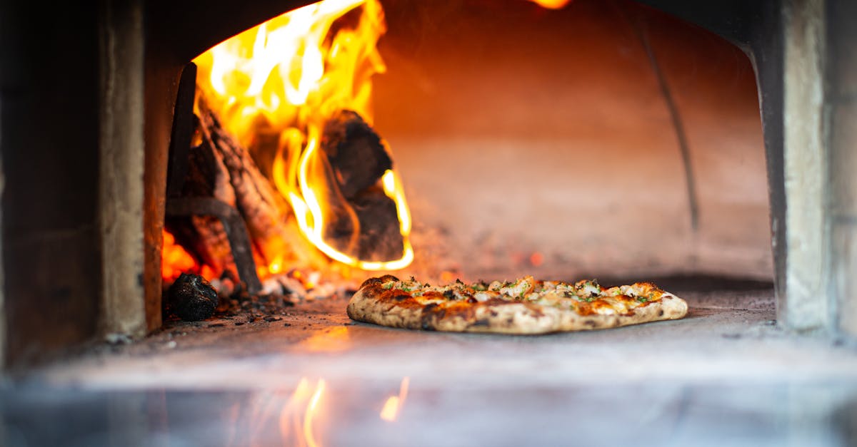 Delicious artisan pizza baking in a traditional wood-fired oven with flames.