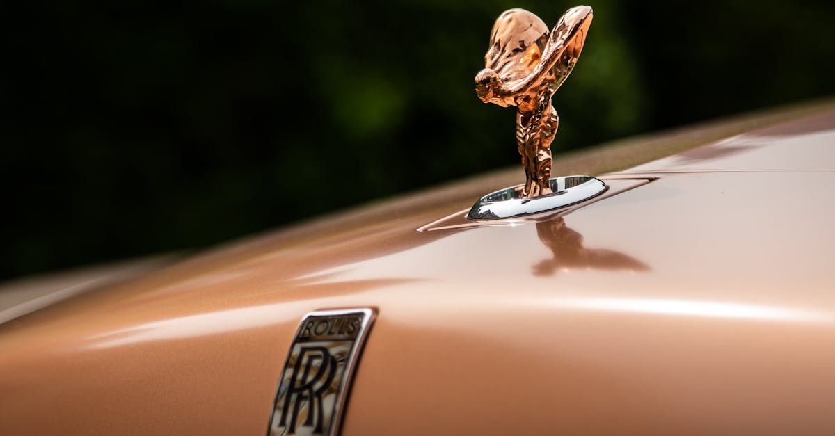 Close-up of a Rolls Royce emblem on a luxury vehicle hood. Classic and elegant design.