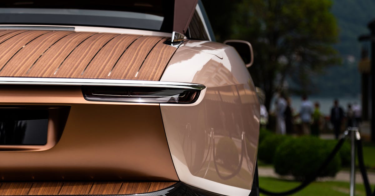 Close-up of a luxury car's rear featuring wooden paneling outdoors.