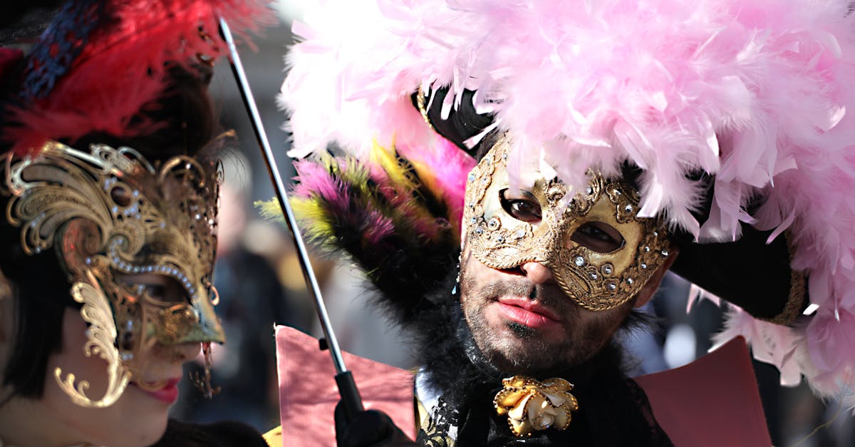 Close-up of two people wearing ornate masks and feathered hats at a Venetian carnival.