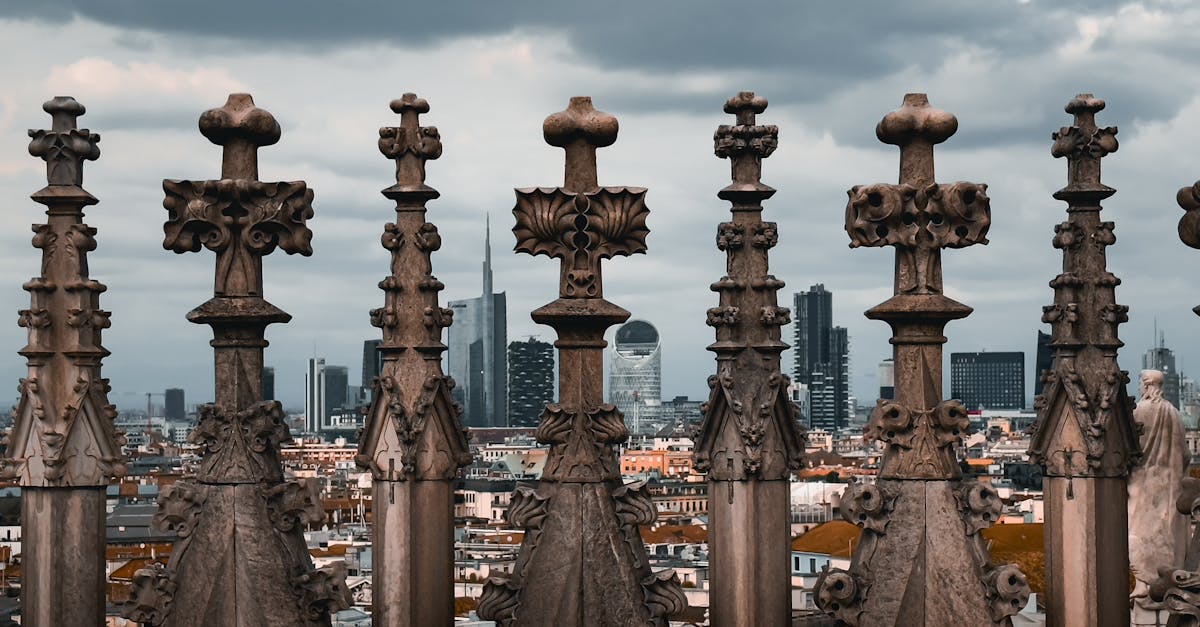 Gothic architecture of Milan Cathedral rooftop with Milan skyline in the background.