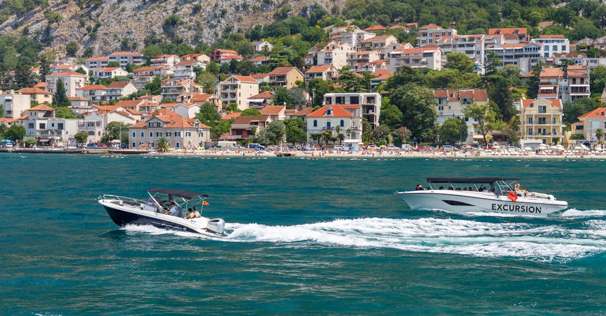 Two boats cruising along the Adriatic coast with a scenic coastal town backdrop.