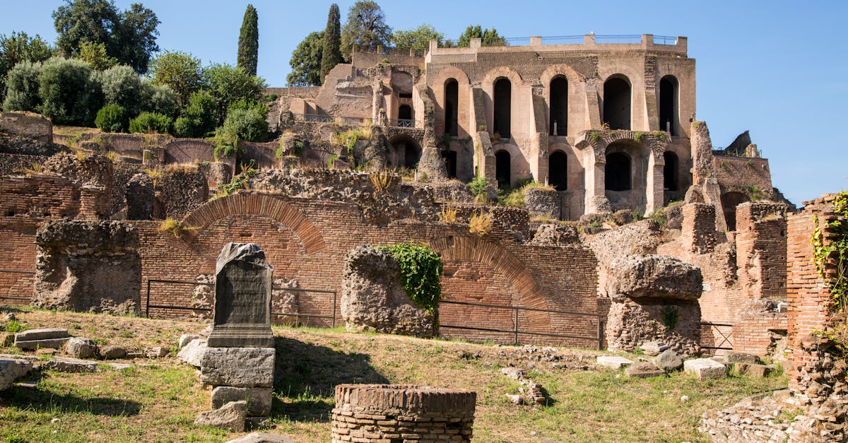 Explore the historic Roman ruins with ancient architecture and vibrant greenery under a clear blue sky.