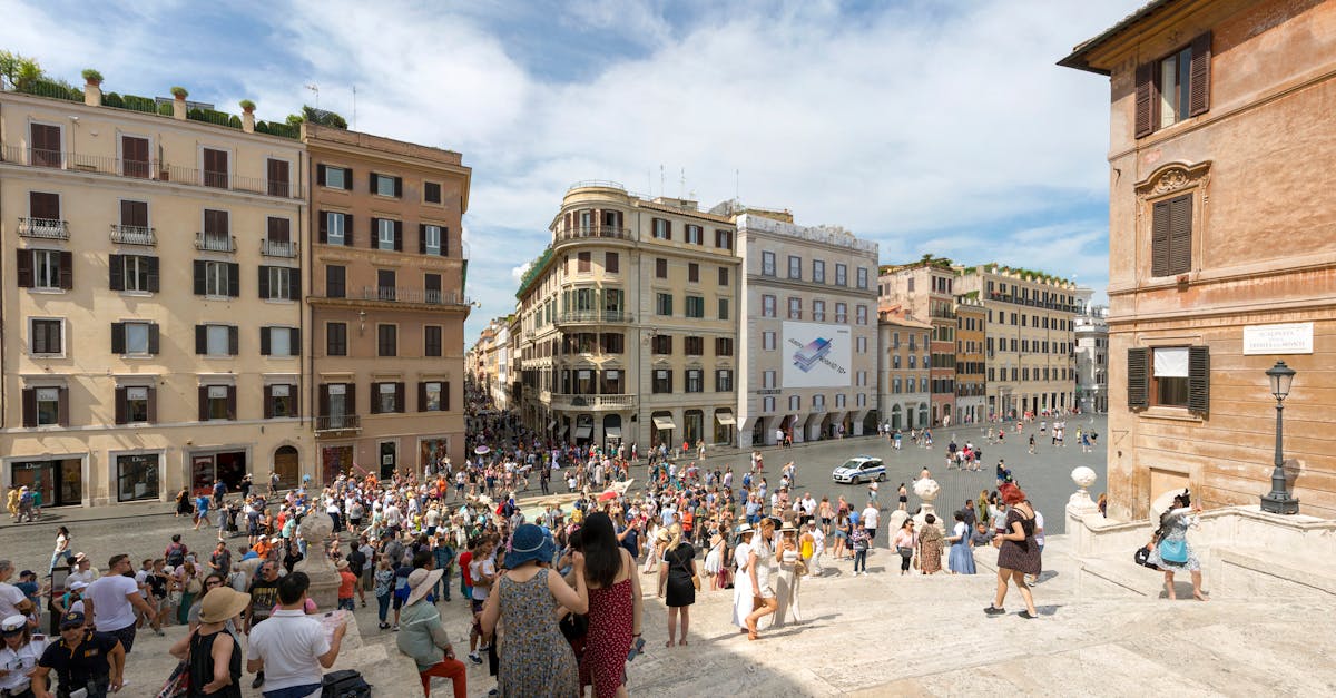 Bustling scene of tourists on the Spanish Steps in Rome under a sunny sky.