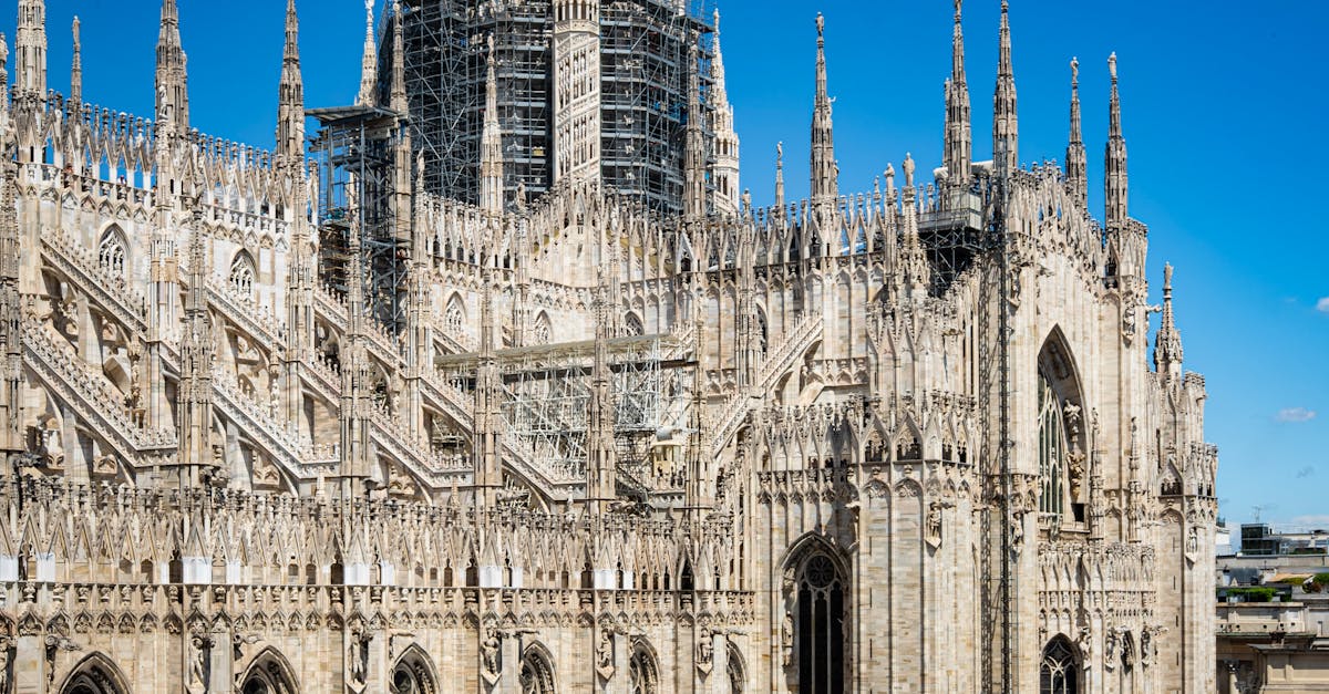 A breathtaking view of the Duomo Cathedral in Milan, showcasing its Gothic architecture under a clear blue sky.