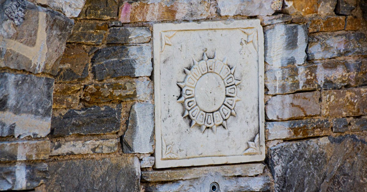 Decorative stone wall featuring a sun design with intricate details symbolizing historical craftsmanship.