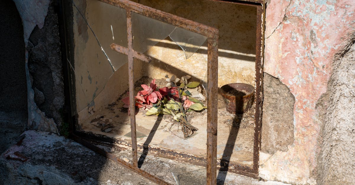 An old grave niche with flowers and a religious icon in Punta del Agua, Argentina.