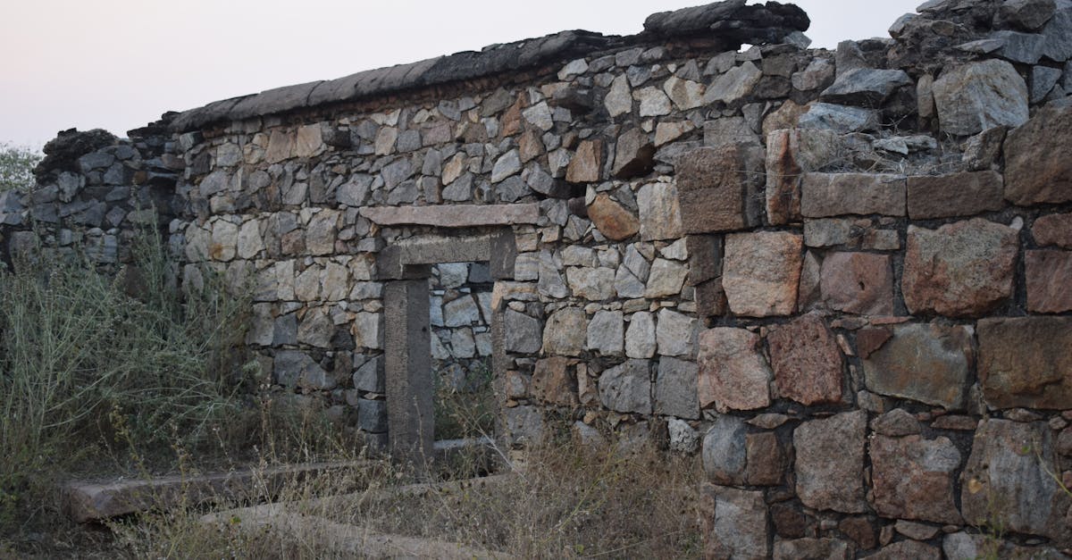 Aged stone wall remnants of a historical building set against an outdoor landscape.