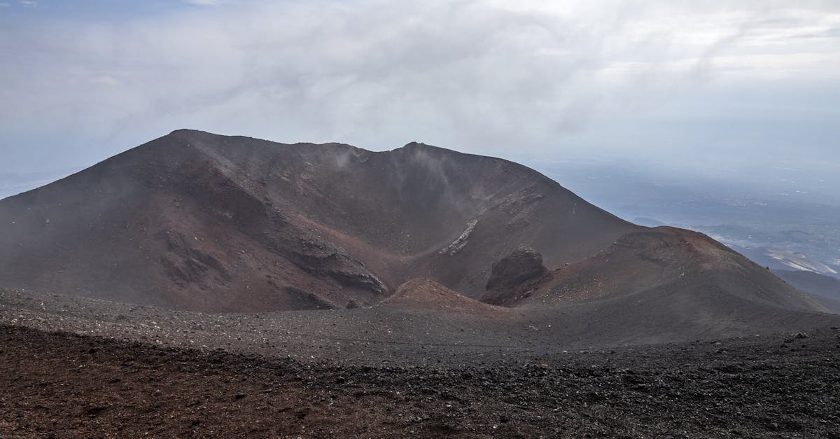 A breathtaking view of a dormant volcano crater under a cloudy sky, showcasing volcanic geology.