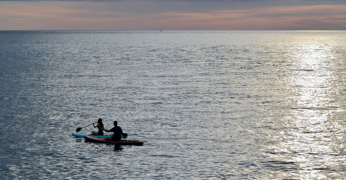 Two people kayaking at sunset in Manado, North Sulawesi, Indonesia.
