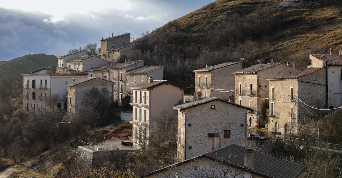 Rustic Italian village houses nestled on a hillside during daylight.