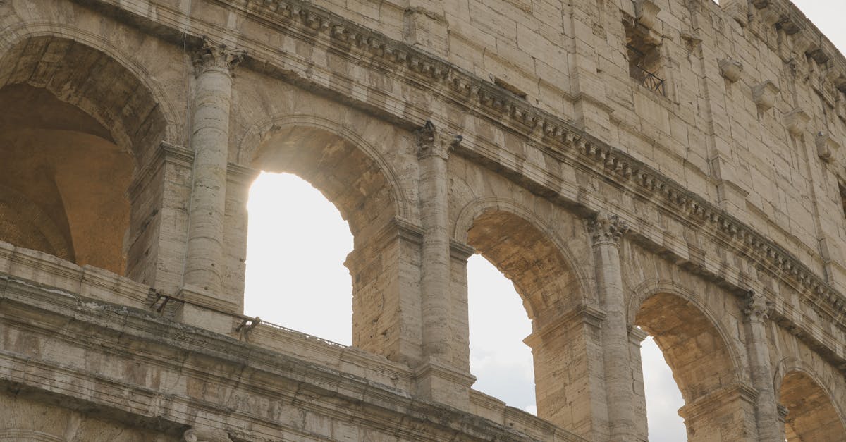 Close-up of the iconic Roman Colosseum arches with sunlight streaming through. Architectural marvel.