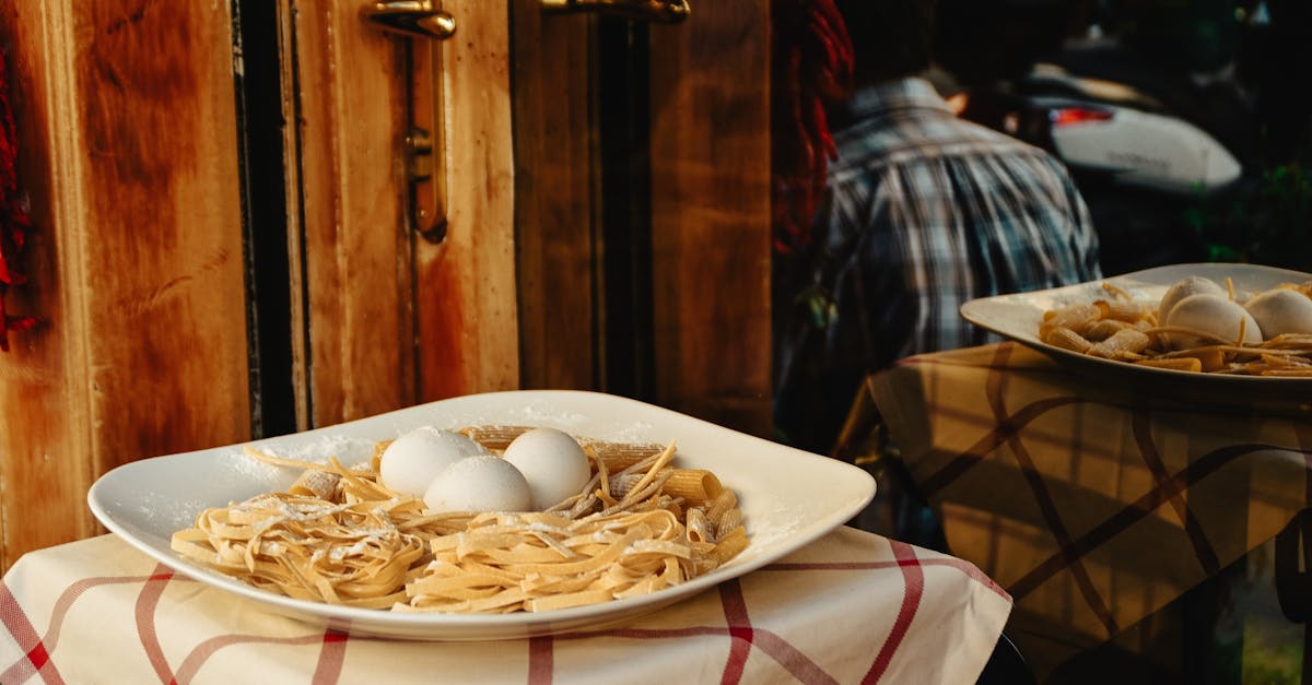 A plate of fresh pasta with eggs is displayed outside a Rome restaurant, showcasing Italian cuisine.