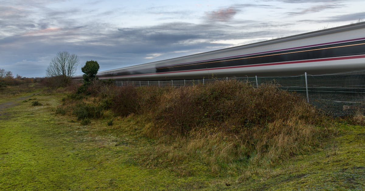 A high-speed train rushes through the green landscape of Craigavon, Northern Ireland, in the early evening.