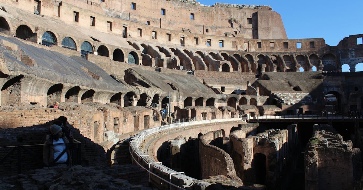 Explore the ancient architecture of the Roman Colosseum under clear skies.