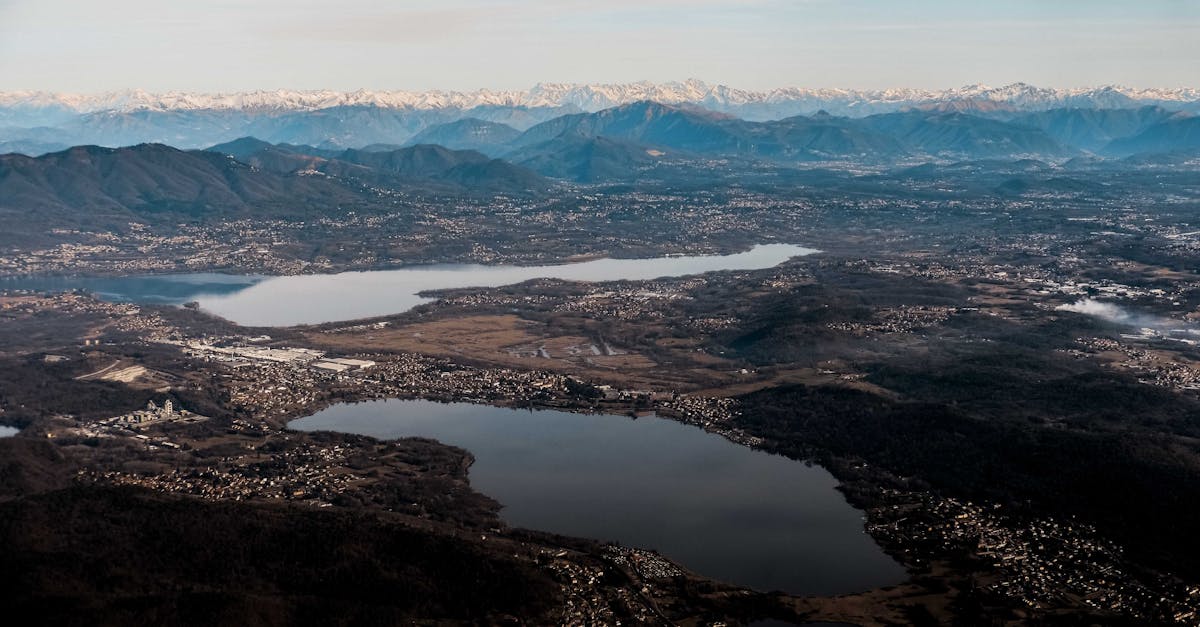 Magnificent view of small shapeless ponds surrounded by rough wavy ridge and dry terrain under cloudy sky in evening