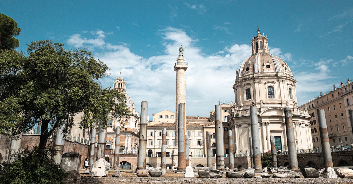 Scenic view of ancient Roman architecture in the heart of Rome, showcasing historical buildings and columns under a clear sky.