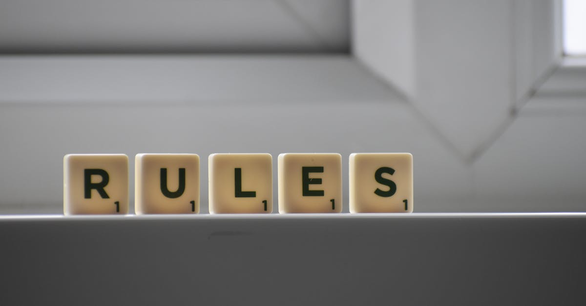 Identical small square shaped cubes with RULES title and numbers on white windowsill near window in house in daylight