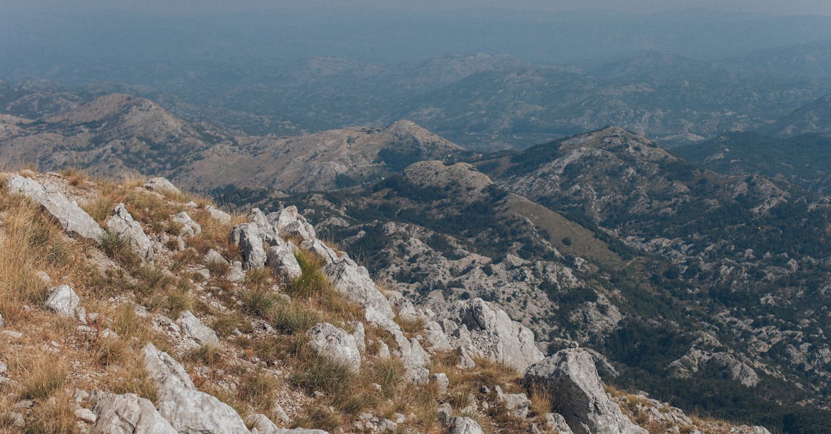 Expansive view of rugged mountain ranges and rocky terrain under a clear sky, ideal for nature exploration.