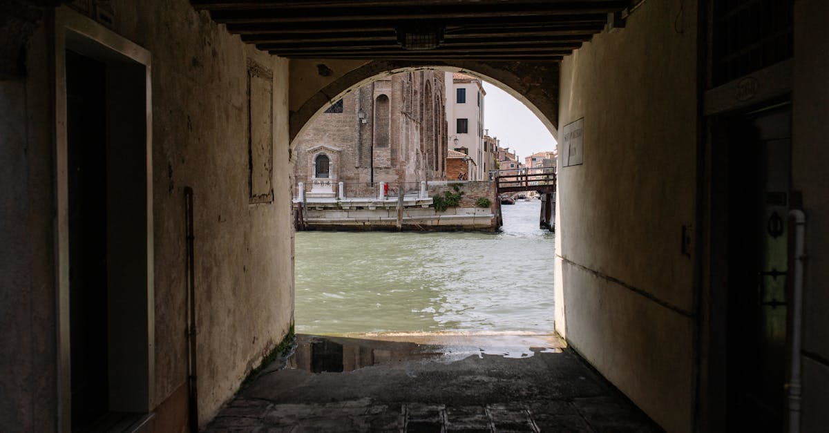 A picturesque view of a Venetian canal seen through a historic archway, capturing the essence of Venice.