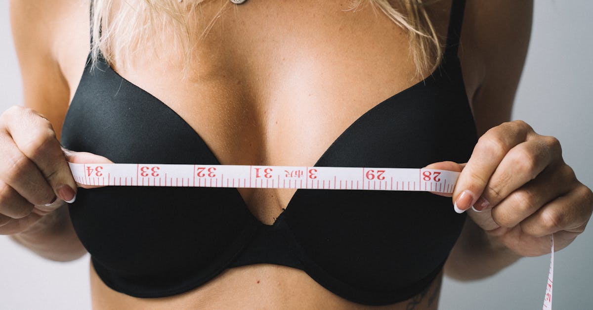 Close-up of a woman measuring her bust with tape for the perfect bra fit.