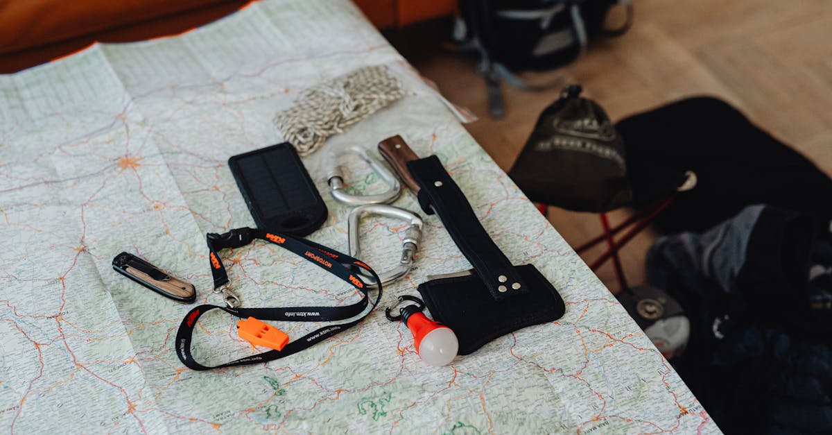 A collection of travel tools and gear laid out on a map, ready for an outdoor adventure.
