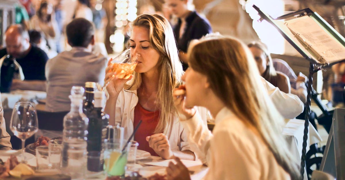 Friends dining in a cozy Italian restaurant, enjoying drinks and food in a lively atmosphere.