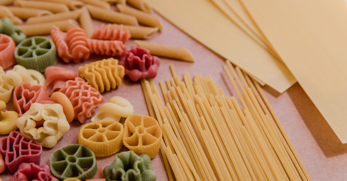 Vibrant selection of uncooked pasta shapes including spaghetti and fusilli on a tabletop.