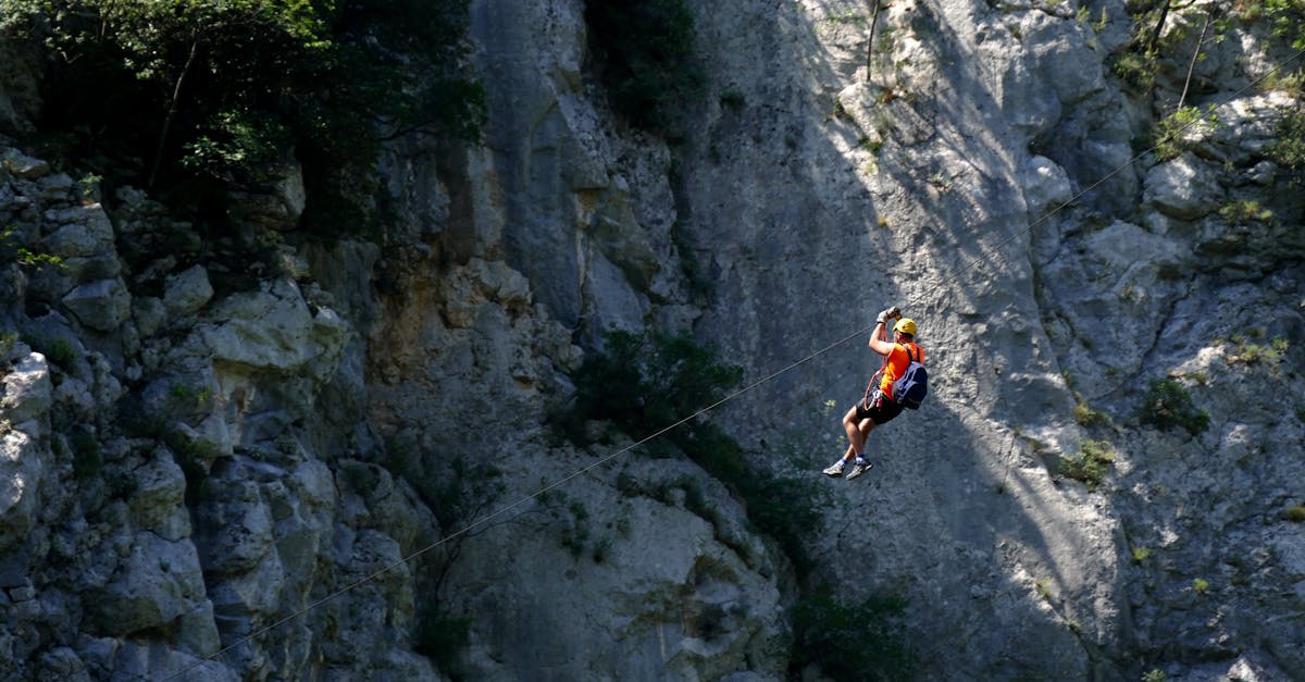 A daring mountaineer ziplining across rocky cliffs in Croatia, showcasing adventure and excitement.